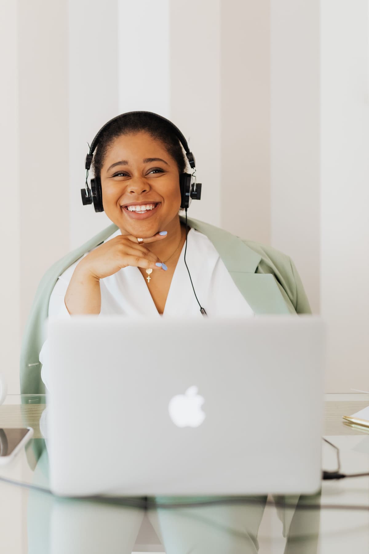 A learner on a headset, joining an online cohort session from her laptop